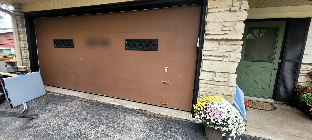 Before: flat brown garage door with two small windows