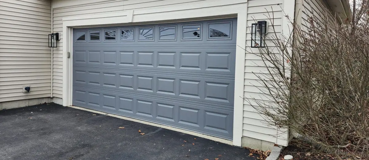 After: grey raised panel garage door with windows on the same home