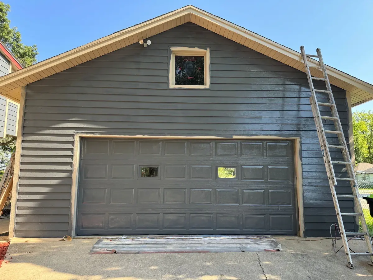 Before: grey raised panel garage door on a blue detached garage