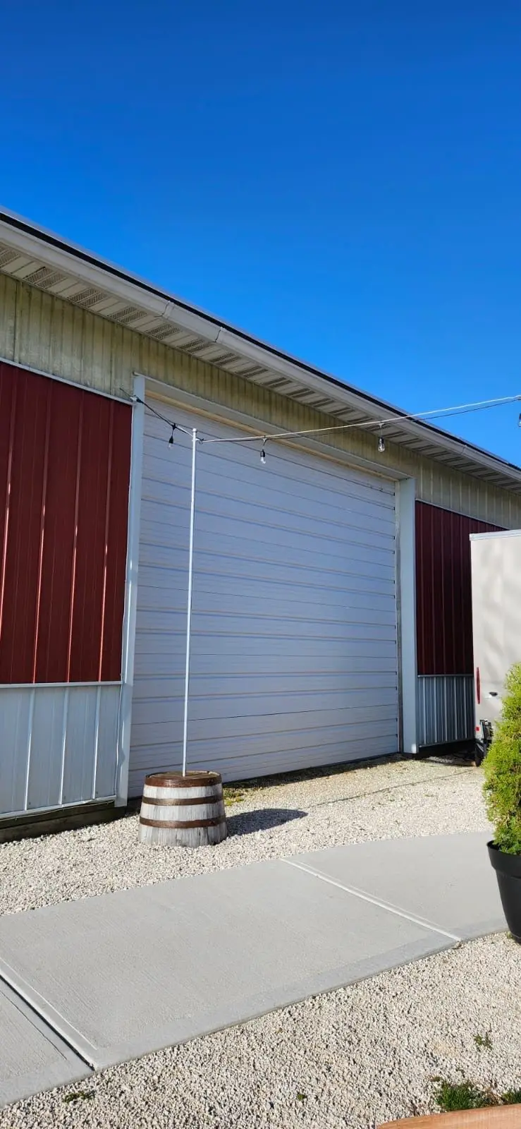 White sectional door installed on a red and white outbuilding