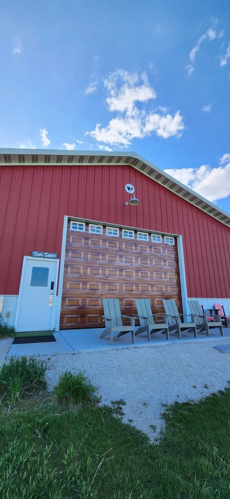 Wood look sectional door on a red metal building