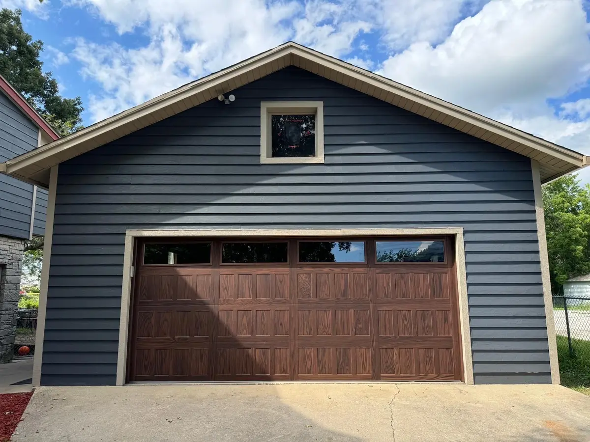 After: wood tone garage door with top windows on the same blue garage