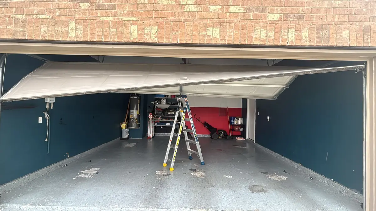 Garage door hanging crooked in the opening after coming off its track