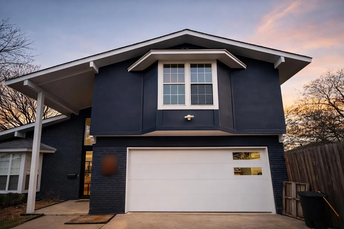 After: white flush modern garage door with offset windows installed by Tier One in Austin 78752, at sunset