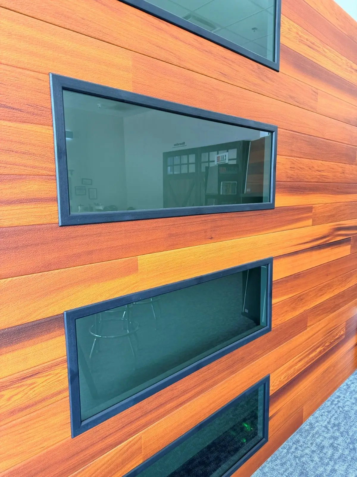 Showroom sample of a wood tone plank garage door with tinted side windows
